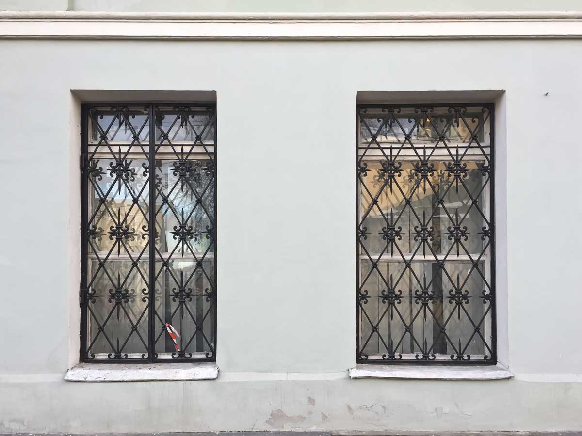 Okna v přízemí zabezpečená kovovými mřížemi.