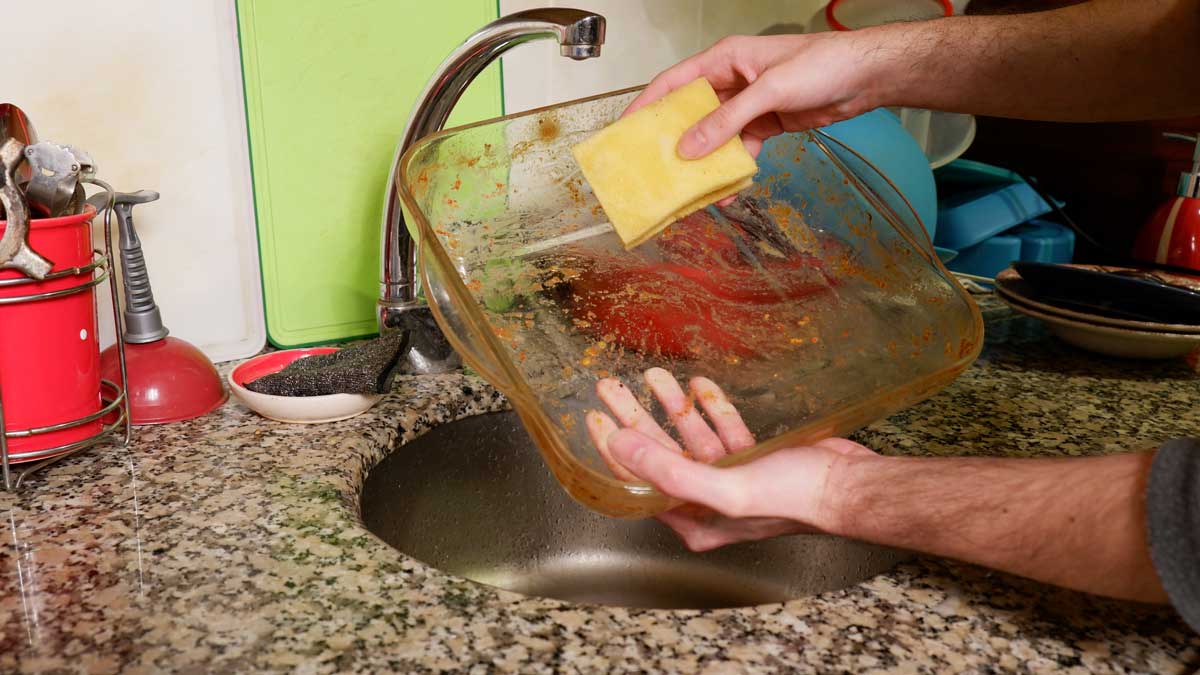 Ruční oplachování zapékací mísy před vložením do myčky nádobí.