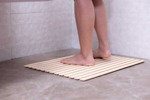 Protiskluzová podložka ve sprše která snižuje riziko uklouznutí na mokré podlaze.