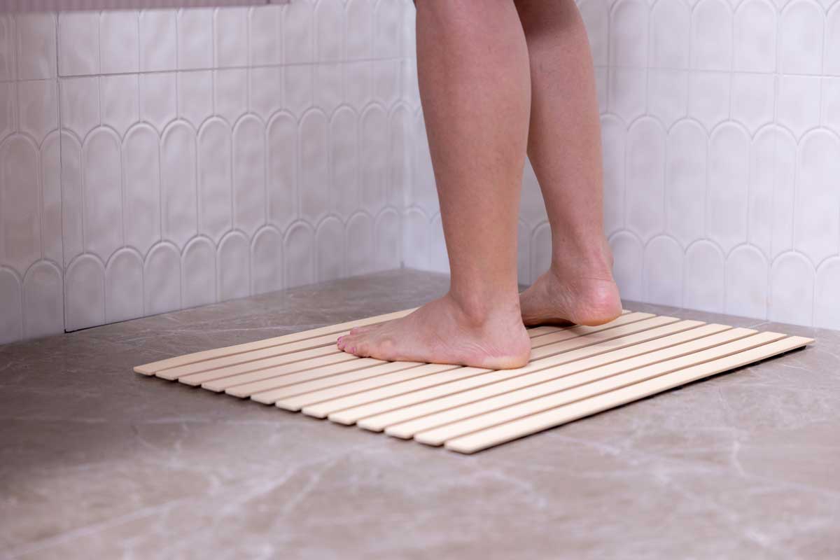 Protiskluzová podložka ve sprše která snižuje riziko uklouznutí na mokré podlaze.