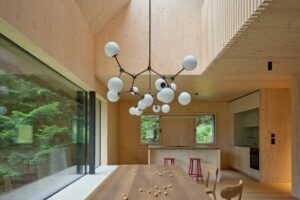 Otevřená denní zóna s jídelním stolem kuchyní a vysokým stropem