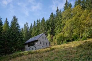 Pohled na dřevěnou fasádu domu zespodu ve svahu