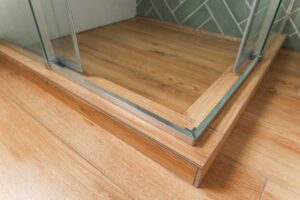 Zvýšený práh sprchového koutu který může být pro seniory rizikem při vstupu do sprchy.