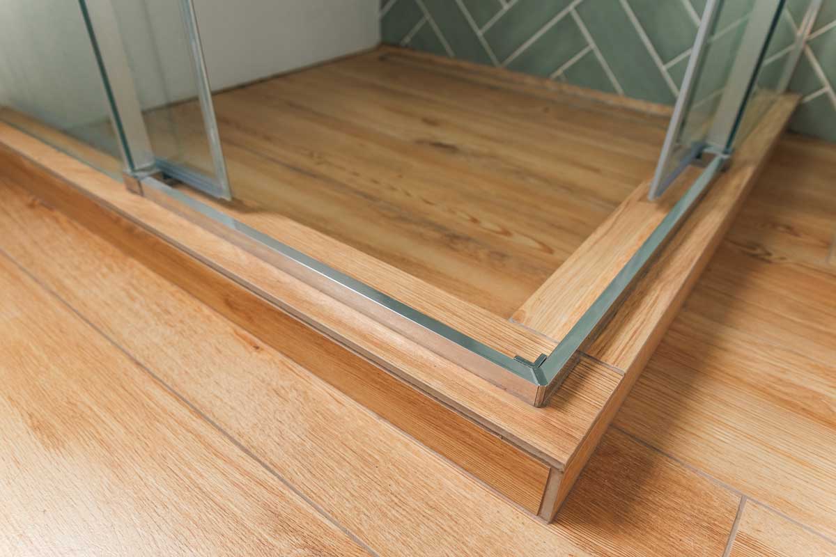 Zvýšený práh sprchového koutu který může být pro seniory rizikem při vstupu do sprchy.