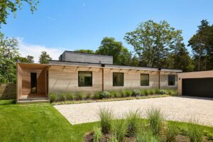 Modulární část domu s dřevěným obkladem ukazuje jednoduchost a čistotu prefabrikované architektury.