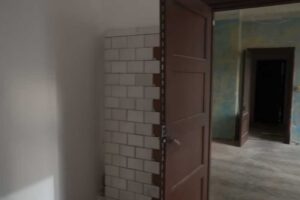 Pohled do bytu před rekonstrukcí odhaluje staré kachlové kamna i původní dispozici místností.