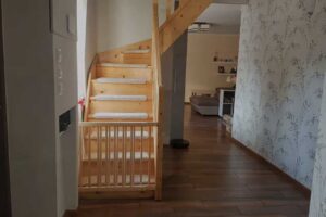 Dřevěné schodiště vedoucí do podkroví v moderně zrekonstruovaném interiéru