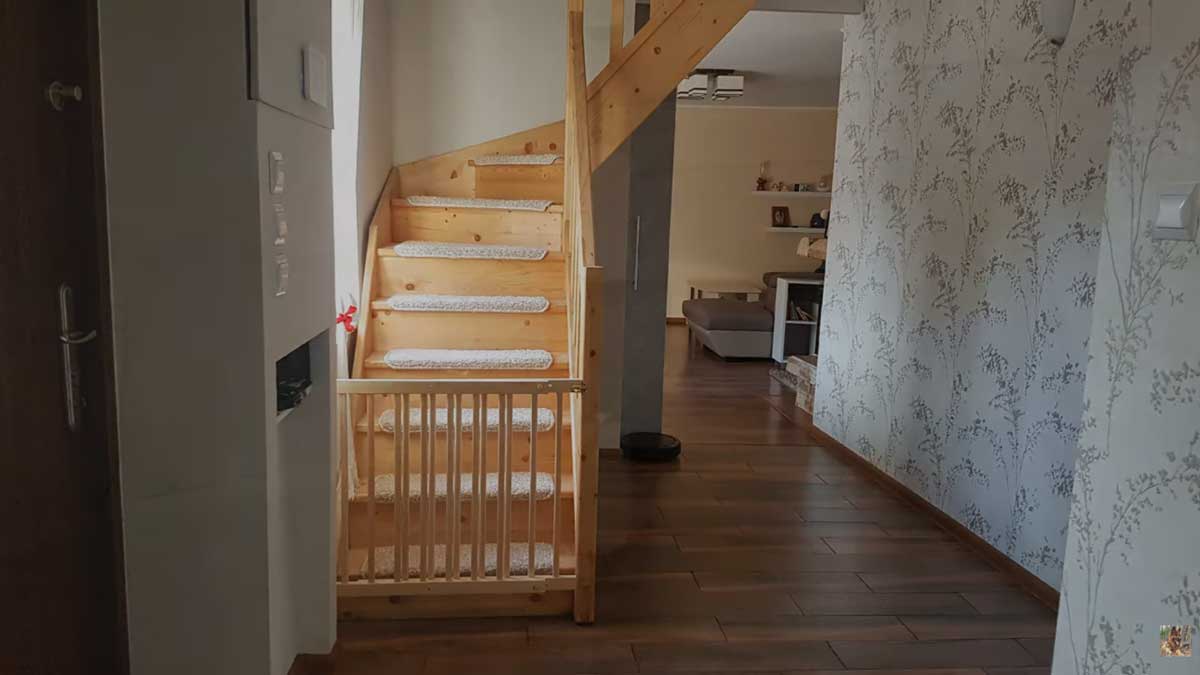 Dřevěné schodiště vedoucí do podkroví v moderně zrekonstruovaném interiéru