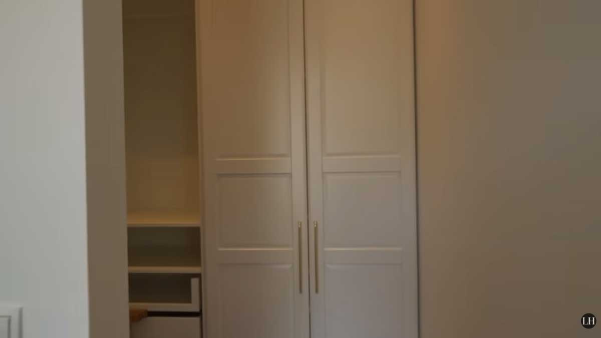 Skrytá šatna za nenápadnými dveřmi, které vypadají jako běžná vestavěná skříň v ložnici.