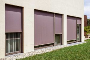 Přízemní okna s venkovními roletami chránícími soukromí obyvatel.