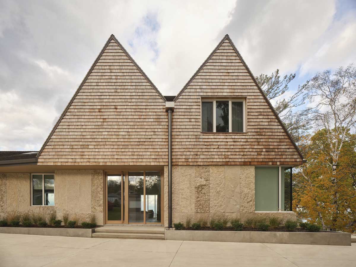 Moderně zrekonstruovaný srub u jezera kombinuje tradiční tvar střechy s přírodní fasádou a klidným okolím