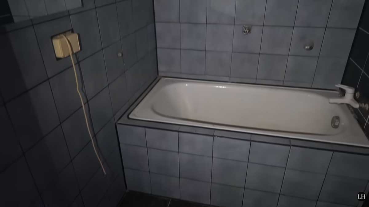 Malá koupelna s vanou a tmavými obklady působila před rekonstrukcí velmi uzavřeně a neprakticky.