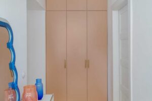 Vestavěná skříň v béžovo růžové barvě v chodbě bytu s dubovou podlahou