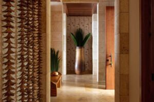 Chodba s dřevěnými prvky, přírodním kamenem a dekoracemi inspirovanými havajskou kulturou