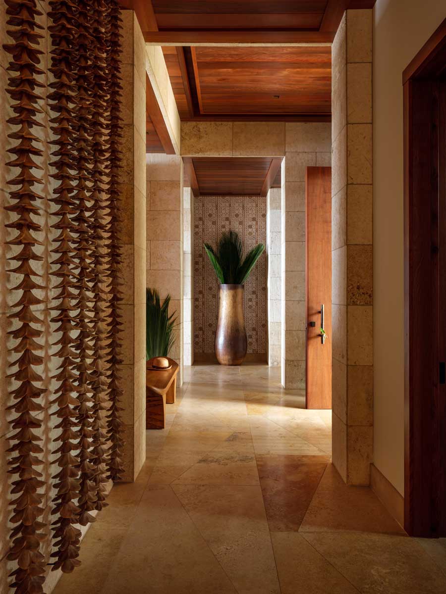 Chodba s dřevěnými prvky, přírodním kamenem a dekoracemi inspirovanými havajskou kulturou