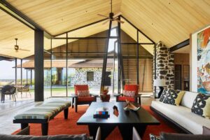 Otevřený obývací prostor s vysokým stropem, dřevem a výhledem do exteriéru