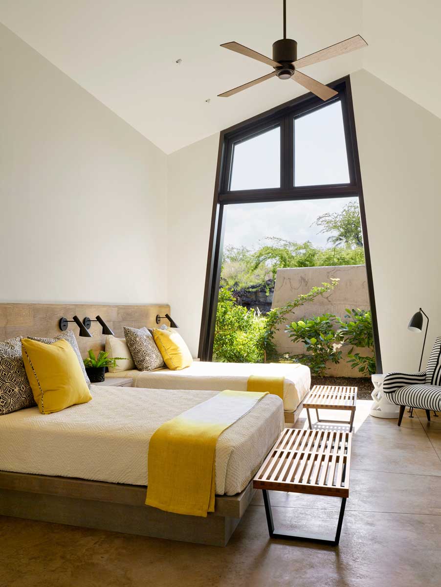 Ložnice s vysokým stropem, velkým oknem a výhledem do zeleně