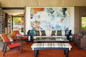 Obývací pokoj s výrazným uměleckým dílem a kombinací textur a materiálů