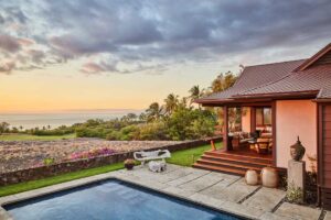 Terasa s bazénem a výhledem na oceán obklopená tropickou krajinou