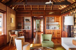 Obývací prostor s dřevěnými prvky a vestavěným barem inspirovaný tropickou architekturou