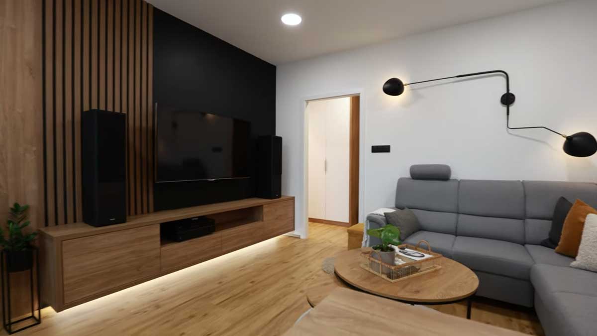 Televizní stěna s dřevěným obkladem a černým panelem vytváří výrazný designový prvek obývacího pokoje.