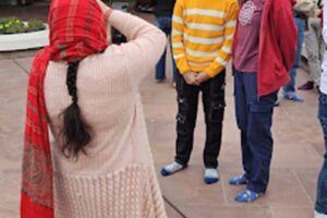 Indická žena fotografuje evropské turisty před moderní budovou v Indii.