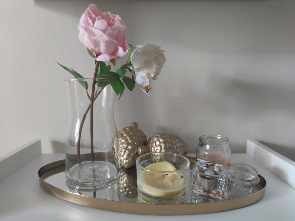 Stylově naaranžovaný konferenční stolek s dekoracemi působí esteticky ale omezuje praktické využití plochy.