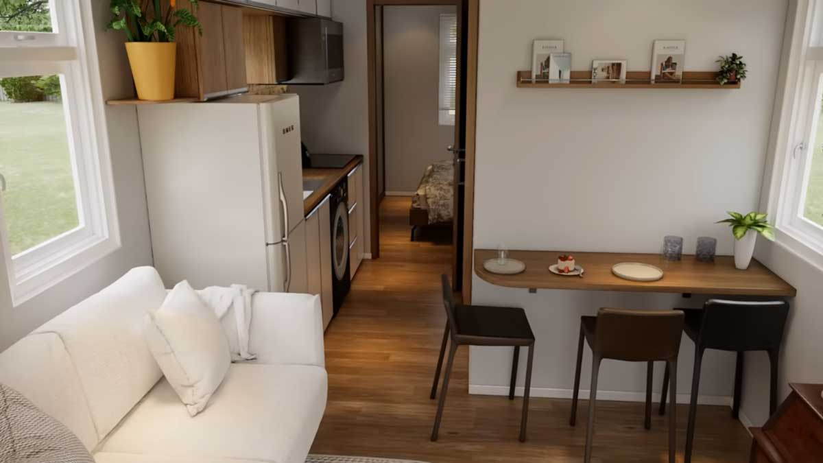 Multifunkční obytný prostor tiny house s kuchyní, jídelním koutem a pohovkou.