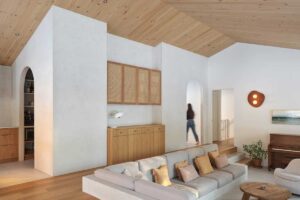 Obývací prostor s dřevěným nábytkem, obloukovými průchody a otevřenou dispozicí působí vzdušně a přirozeně