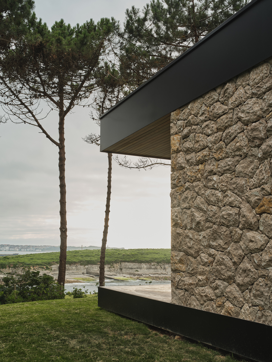 Detail kamenné fasády domu ukazuje spojení tradičního materiálu a současných architektonických linií.