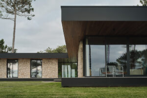 Prosklený roh domu s krytou terasou nabízí klidné posezení a výhled do zeleně.