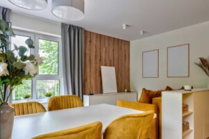 Obývací pokoj s hořčicově žlutými židlemi dřevem a neutrálními odstíny