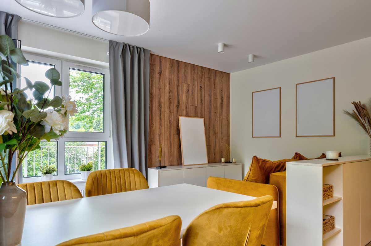 Obývací pokoj s hořčicově žlutými židlemi dřevem a neutrálními odstíny