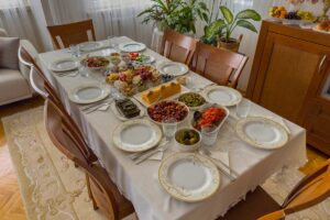 Prostřený jídelní stůl s pevnou konstrukcí a pohodlnými židlemi tvoří základ každodenního stolování.