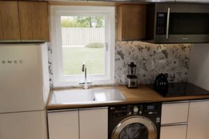 Malá kuchyně v tiny house s retro lednicí a vestavěnými spotřebiči.