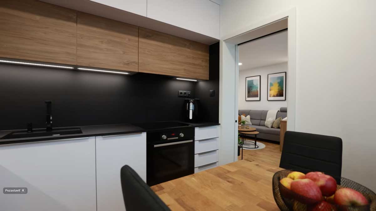 Úzká paneláková kuchyně s jídelním stolem využívá prostor efektivně a díky světlým plochám nepůsobí stísněně.