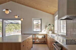 Prostorná kuchyň s masivním ostrůvkem, dřevem a světlými materiály vytváří funkční a klidné zázemí