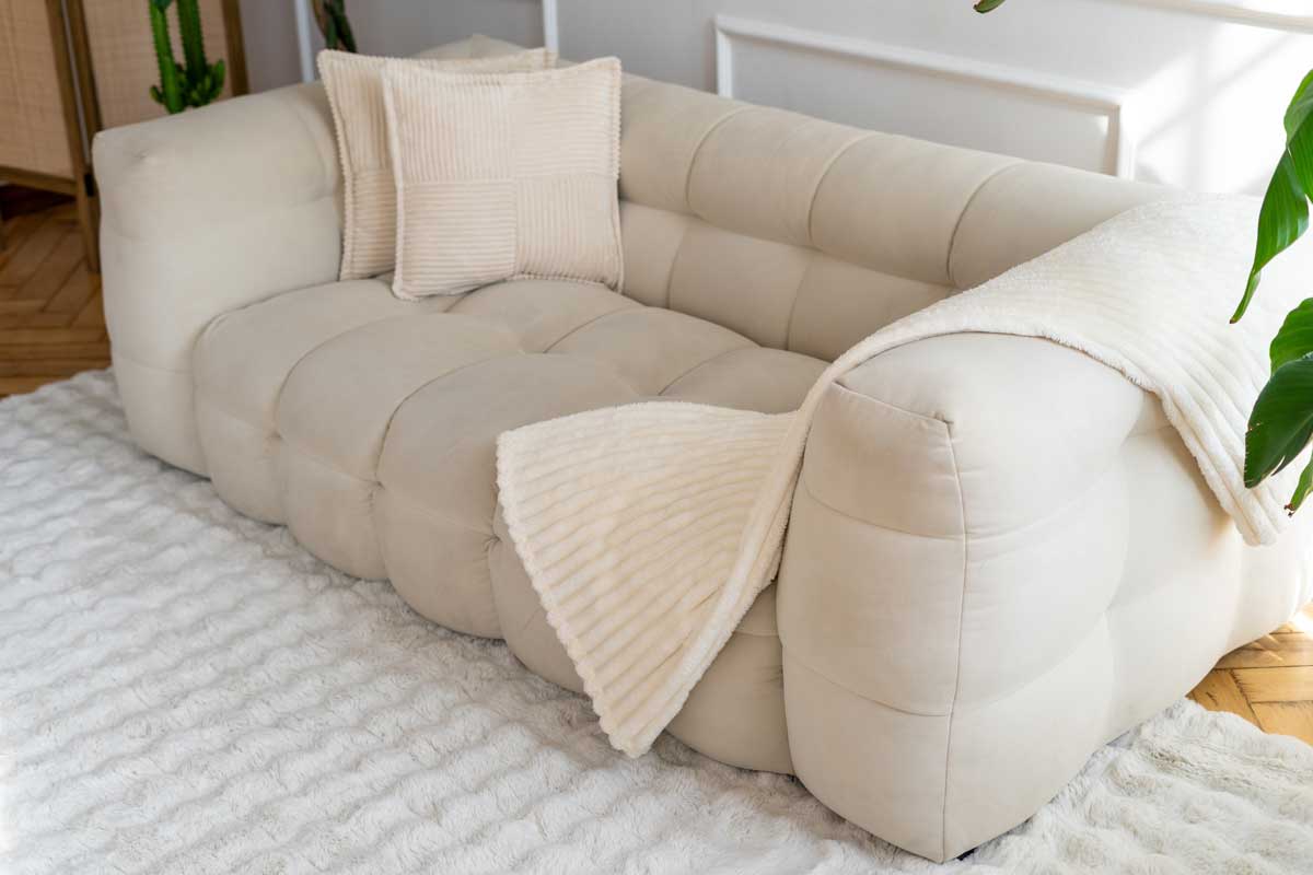 Detail měkké pohovky s kvalitní textilií a výraznou strukturou ukazuje jak materiál ovlivňuje celkový dojem z nábytku