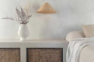 Vestavěná lavice s úložnými koši, keramická váza a závěsné světlo vytvářejí harmonický kout v přírodním stylu