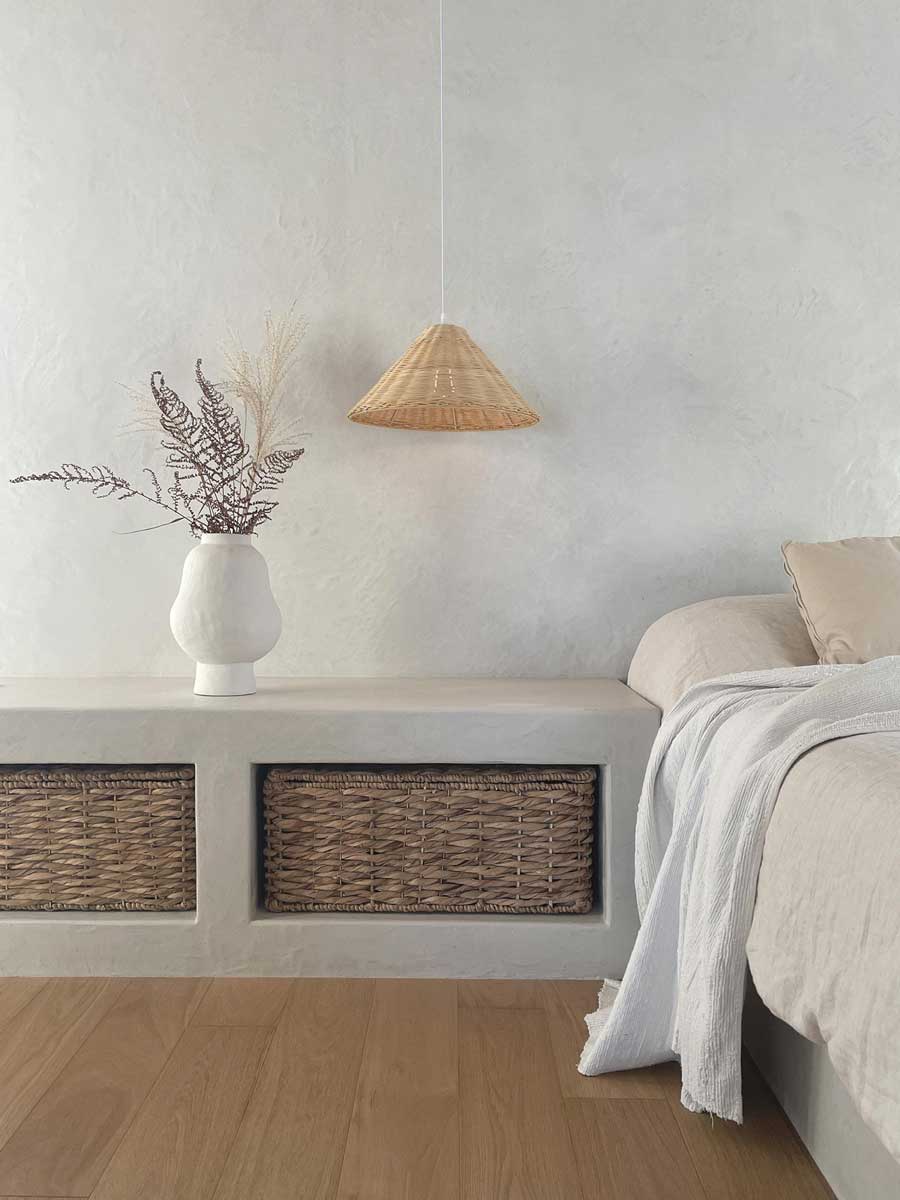 Vestavěná lavice s úložnými koši, keramická váza a závěsné světlo vytvářejí harmonický kout v přírodním stylu