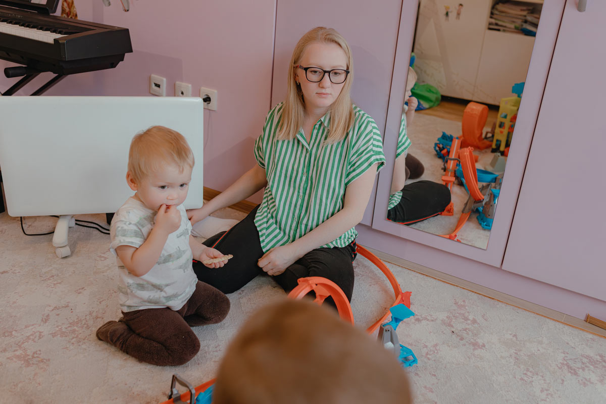 Zrcadlová skříň v dětském pokoji odráží hračky, nábytek a běžný každodenní ruch domácnosti.