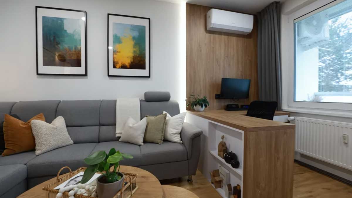 Obývací pokoj doplněný o pracovní zónu s dřevěným stolem přirozeně propojuje práci a relaxaci.