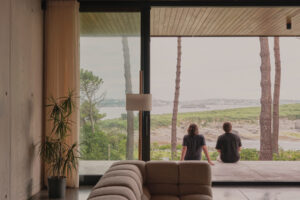 Obývací pokoj s velkoformátovým zasklením plynule přechází na terasu s výhledem na moře.