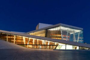 Moderní budova opery v Oslu s rozsáhlými prosklenými plochami jako ukázka využití skla v současné architektuře.