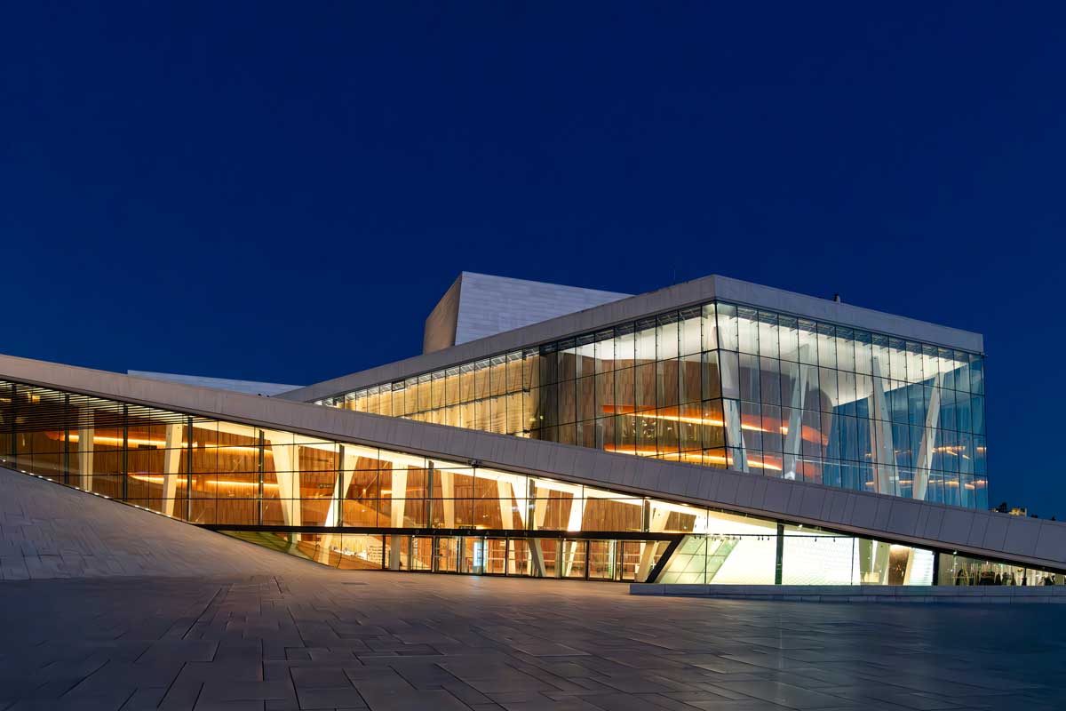 Moderní budova opery v Oslu s rozsáhlými prosklenými plochami jako ukázka využití skla v současné architektuře.