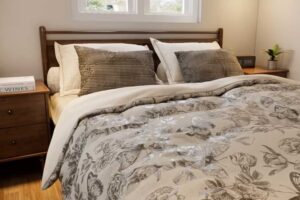 Manželská postel v tiny house s jemným květinovým povlečením.