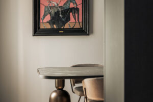 Pracovna je laděná v tlumených tónech a doplněná solitérním stolem a uměleckým dílem, které prostoru dodává osobitý charakter.