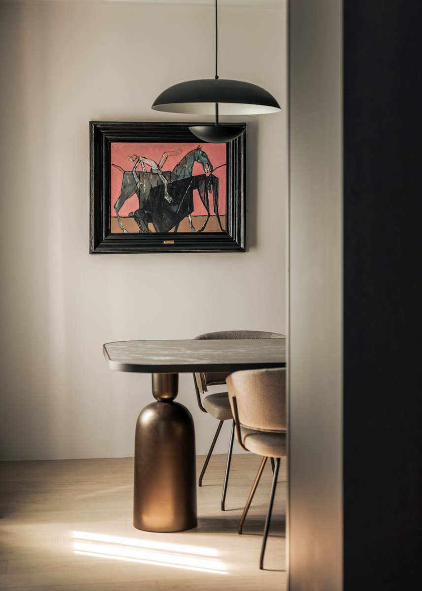 Pracovna je laděná v tlumených tónech a doplněná solitérním stolem a uměleckým dílem, které prostoru dodává osobitý charakter.