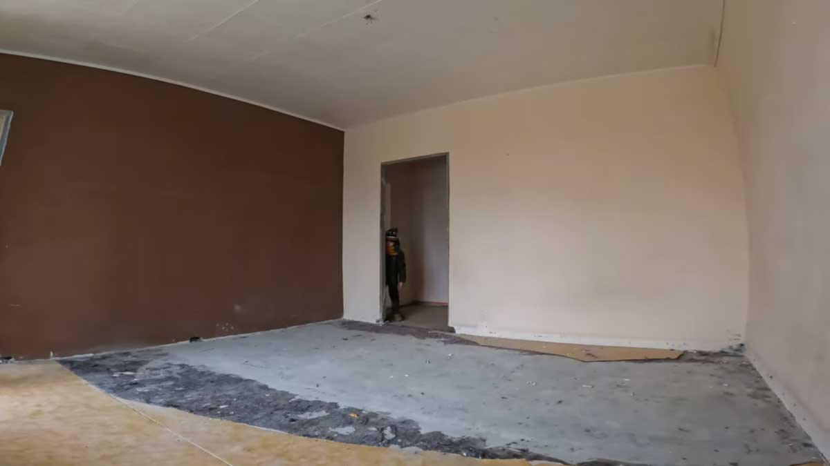 Vybouraný pokoj s odhalenou podlahou a stěnami ukazuje radikální začátek rekonstrukce panelákového bytu.