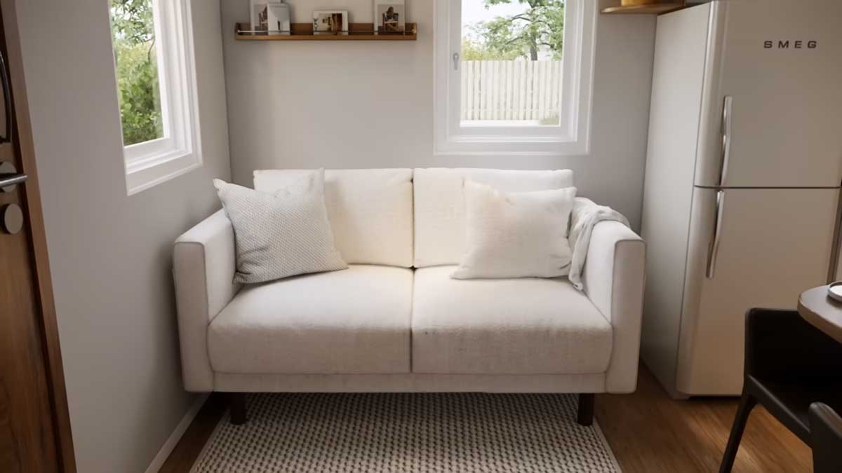 Malá světlá pohovka v obytné části tiny house vedle kuchyně.